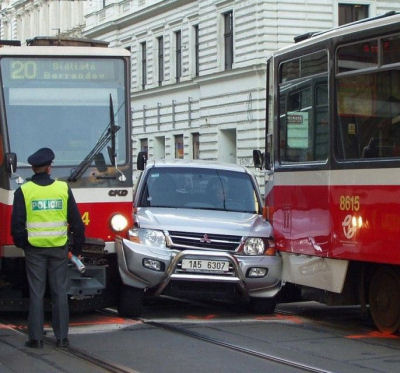 An image of a suv blocked between two trams.